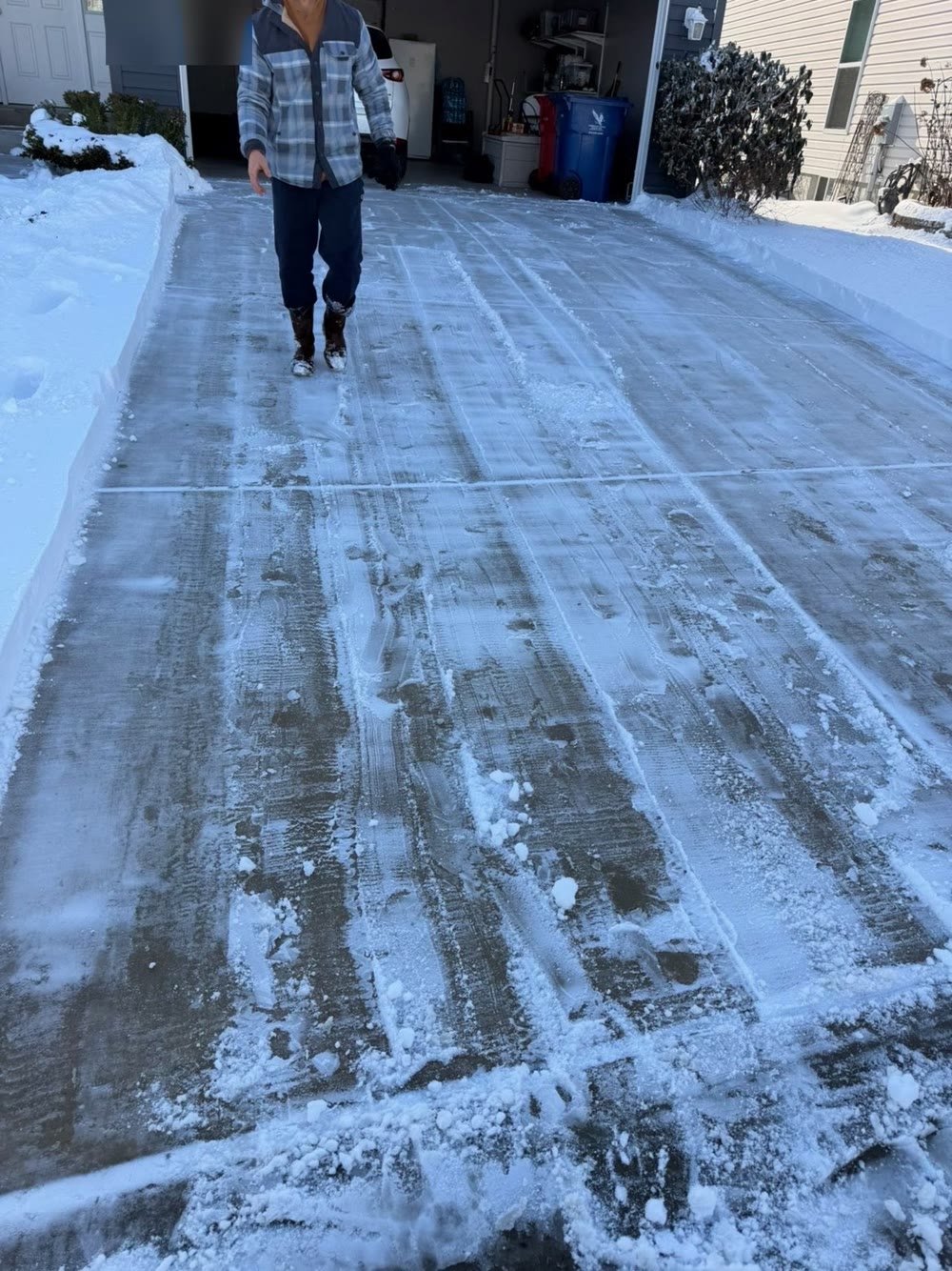 The same driveway cleared down to bare pavement after Precision Outdoor Solutions plowed it